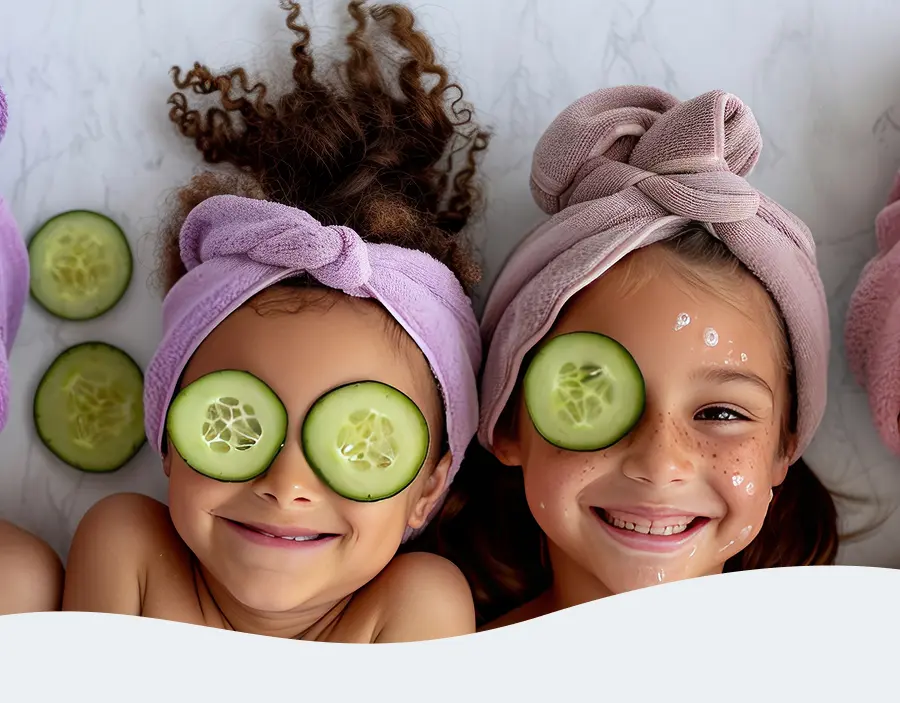Two children wearing cucumber eye masks and enjoying a spa day together at Pause Spa