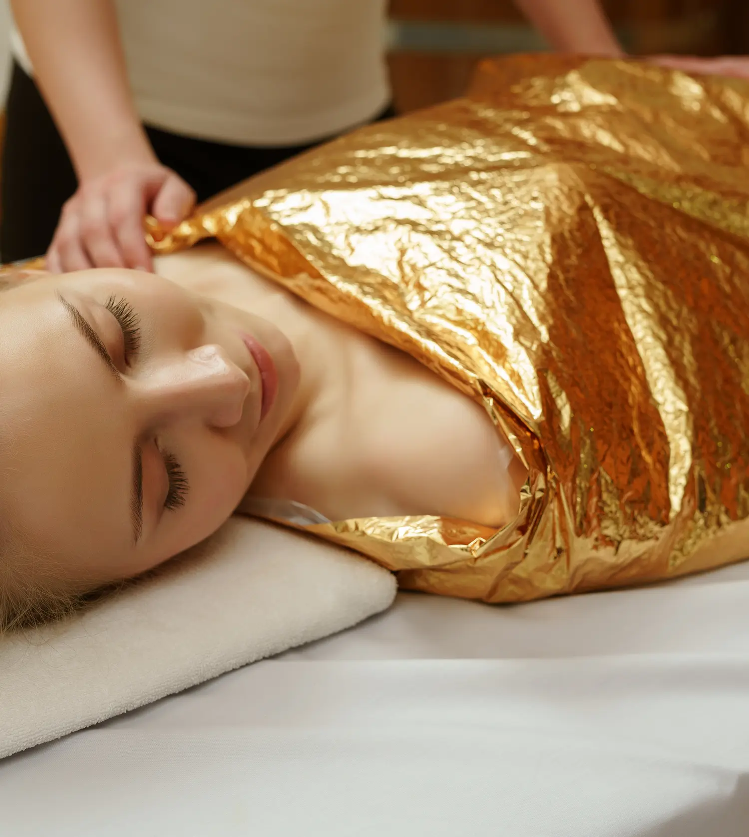 Woman lying on a treatment bed with a body wrap covering her body during her Body Wrap treatment at Pause Spa