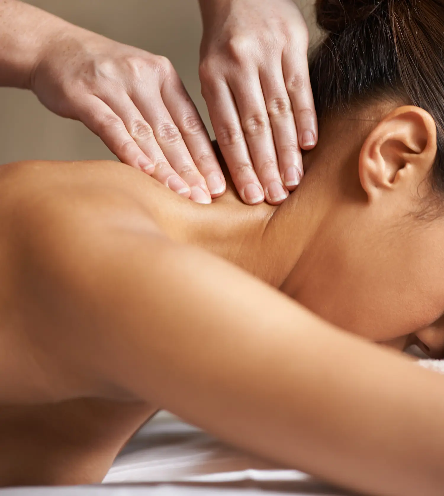 Young woman enjoying a relaxing neck massage during her Back, Neck & Head Massage experience at Pause Spa