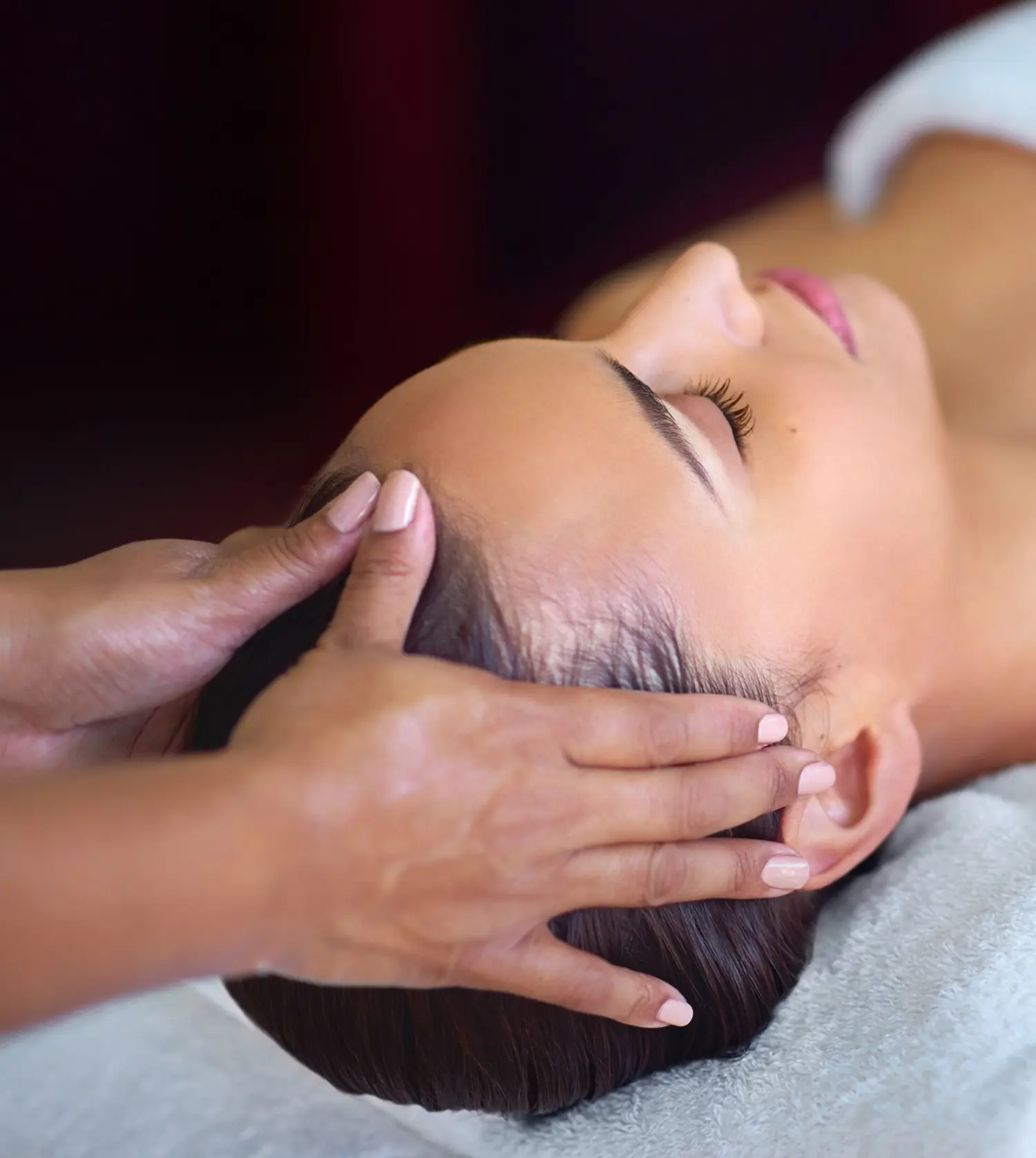 Woman enjoying a scalp massage while lying on her back during her Revitalise Journey spa experience at Pause Spa
